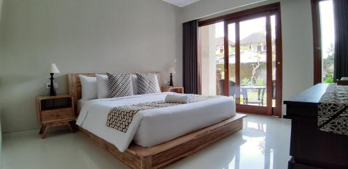 乌布Kyumari的卧室设有一张白色大床和一扇窗户。