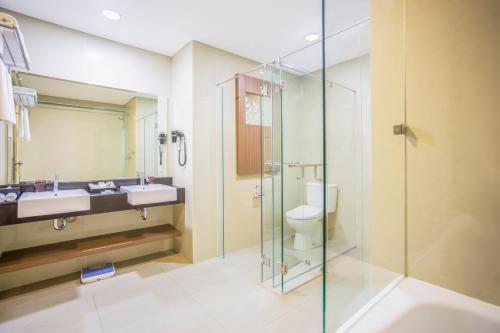雅加达格玛腰兰瑞士贝林酒店的一间带玻璃淋浴和卫生间的浴室