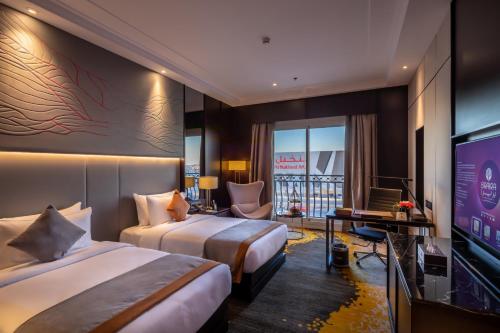 利雅德Braira Al Nakheel的酒店客房设有两张床和一台平面电视。