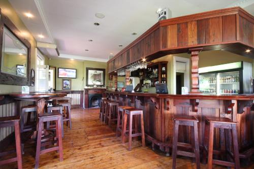 BalfourKatberg Eco Golf Estate的餐厅内带木制酒吧凳的酒吧