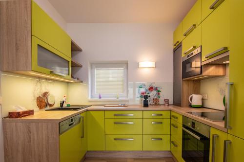 兹诺伊莫Apartment Aloha的绿色厨房,配有黄色橱柜和水槽