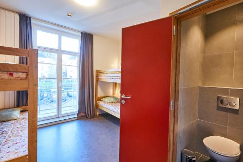 布鲁塞尔雅克布雷尔青年旅舍的一间带红色门和卫生间的浴室