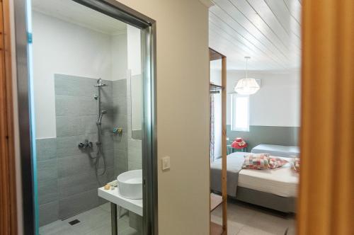 阿凯松米茂扎海滩酒店的带淋浴和盥洗盆的浴室以及1张床。