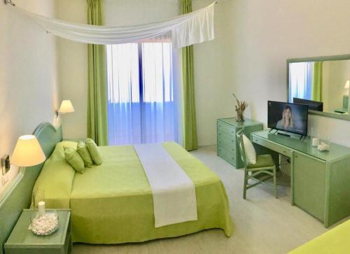 维耶斯泰加尔加诺酒店的一间卧室配有一张绿色的床和一张带电脑的书桌