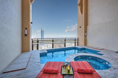 迪拜阿加恩罗塔纳酒店 - 迪拜媒体城的一个带桌子的游泳池和一个阳台