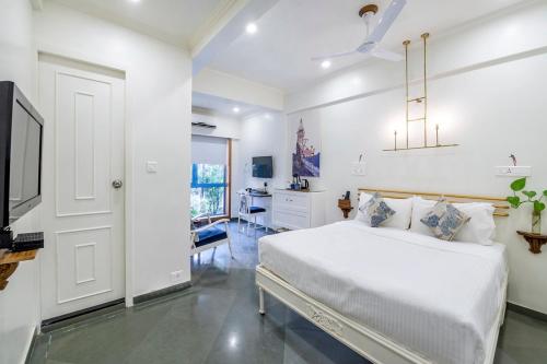 孟买肯普斯角酒店的白色卧室配有床和书桌