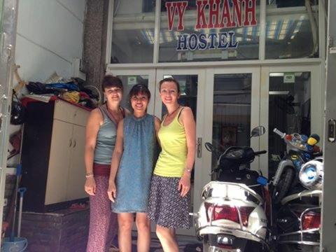 胡志明市VY庆旅馆 的三名妇女在摩托车前摆上一张照片