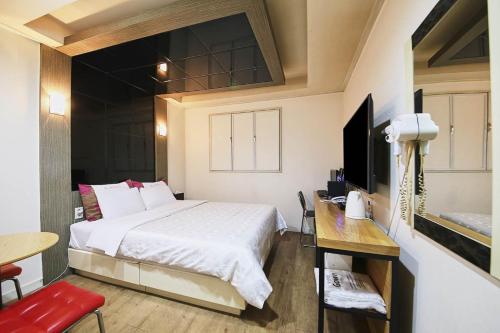 首尔K2 Motel的一间卧室配有一张床、一张桌子和一台电视