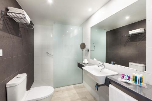 卡亚俄萨尔瓦赫Hotel Tropical Park的浴室配有白色卫生间和盥洗盆。