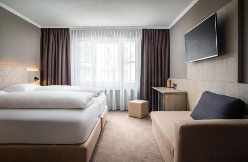慕尼黑AWA Hotel的酒店客房,设有两张床和一张沙发