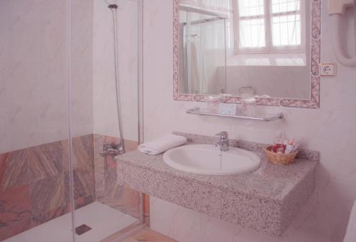 特鲁希略维多利亚酒店的一间带水槽、镜子和淋浴的浴室
