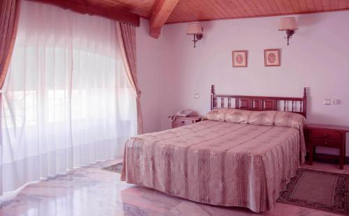 特鲁希略维多利亚酒店的一间卧室设有一张床和一个大窗户
