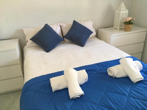 贝纳尔马德纳Avda de las Palmeras Apartment的一张蓝色和白色的床,上面有毛巾