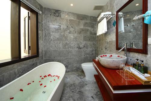 会安Threeway Riverside Villa的带浴缸和盥洗盆的浴室