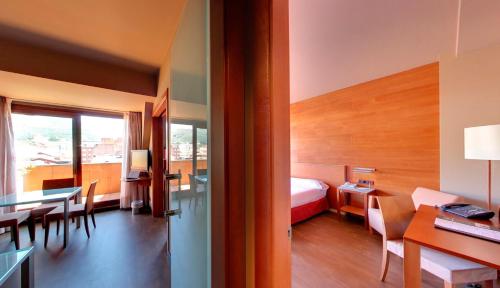 奥维多西尔肯纳兰科纪念碑酒店的酒店客房带一张床、一张桌子和椅子