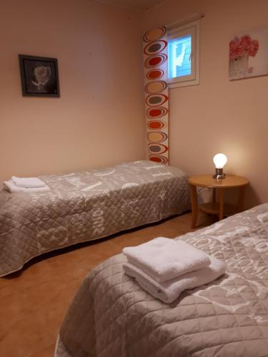 卡拉约基Apartment Varikko Kalajoki的客房设有两张床、一张桌子和一扇窗户。