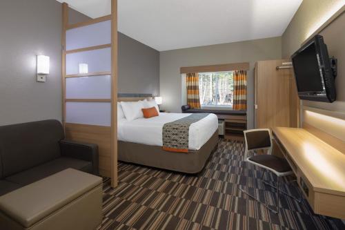 佛罗伦萨Microtel Inn & Suites by Wyndham Florence的配有一张床和一台平面电视的酒店客房