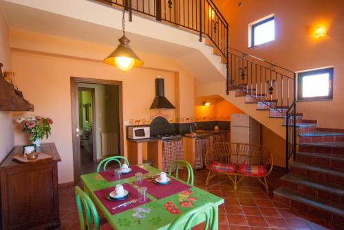 尼科洛西瑞纳罗萨住宿加早餐酒店的一间带绿桌的客厅和一间厨房