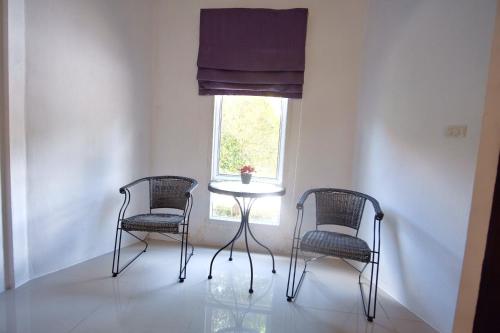 拉迈拉迈度假村的窗户客房内的两把椅子和一张桌子