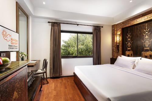 清迈Holiday Garden Hotel & Resort SHA EXTRA PLUS的酒店客房设有床和窗户。