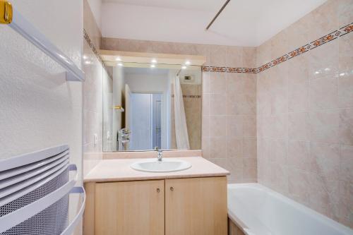 圣艾格夫Vacancéole - Les Calanques Du Parc的浴室配有盥洗盆和浴缸。