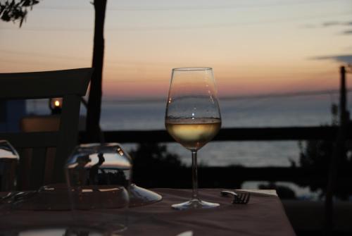 萨兰达萨兰达酒店的坐在桌子上一边欣赏日落,一边品尝葡萄酒