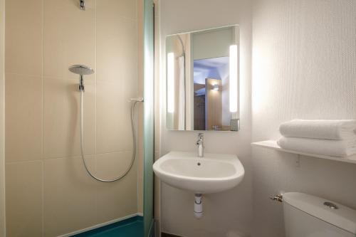 加来B&B HOTEL Calais Centre St Pierre的浴室配有盥洗盆和带镜子的淋浴