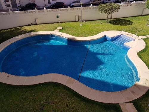 滨海罗克塔斯Apartamento Aguadulce Moreno的享有大型蓝色游泳池的顶部景致