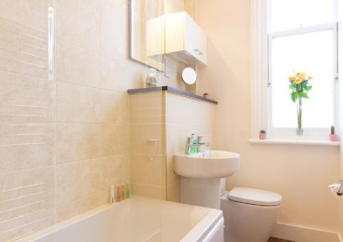 伊斯特布恩Thorne Lodge的浴室配有卫生间、盥洗盆和浴缸。