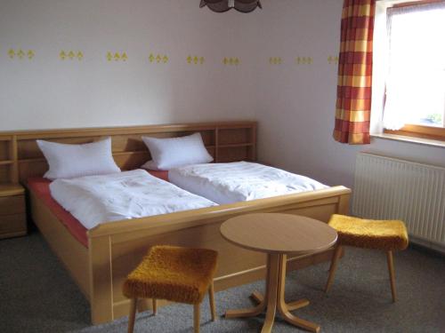 波滕施泰因Ferienwohnungen Haberberger的一间卧室配有一张带桌子和两把椅子的床