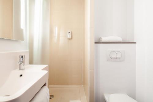 圣但尼B&B HOTEL Paris Saint-Denis Pleyel的白色的浴室设有水槽和淋浴。