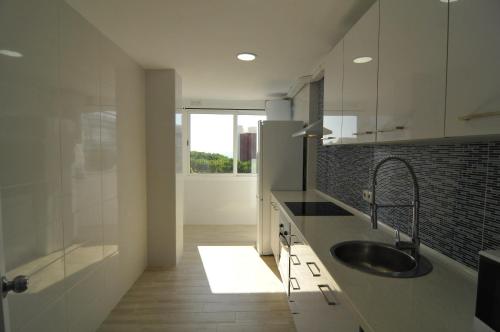 圣苏珊娜HomeHolidaysRentals Solmar的白色的厨房设有水槽和淋浴