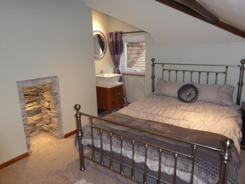 多尔威泽兰Lledr House Hostel near two Zip World sites的一间卧室配有一张带壁炉和水槽的床。