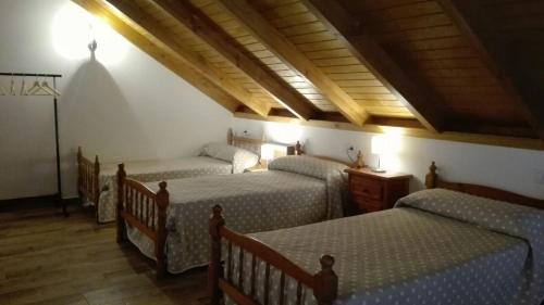 Los BadalejosVilla Almudena的客房设有三张床和木制天花板。