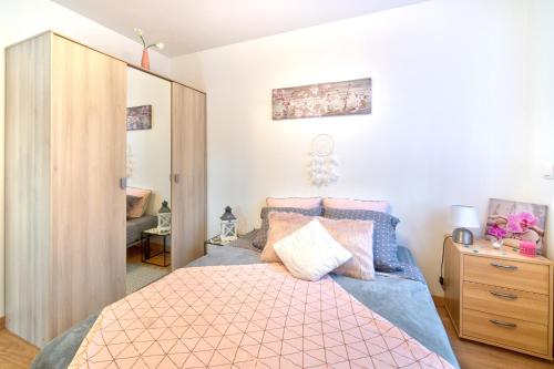 CersGîte Figues et Caraïbes的一间卧室配有一张带粉红色和蓝色床单的床
