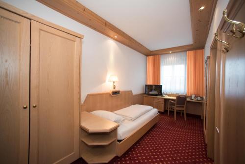 伊斯马宁Hotel und Gasthof Soller的一间小卧室,配有一张床和一张书桌