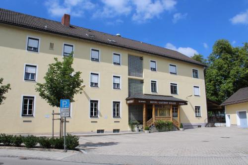 伊斯马宁Hotel und Gasthof Soller的一座黄色的大建筑,前面有停车标志