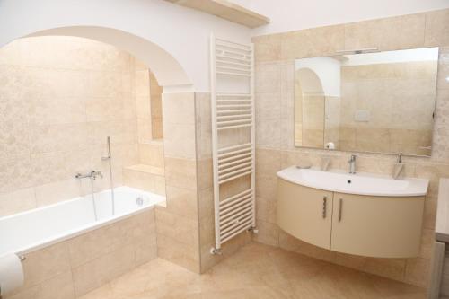 波贾尔多L'ANTICA PIETRA Casa Vacanza Salento的浴室配有盥洗盆、浴缸和镜子