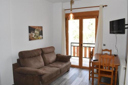 阿罗约弗里奥MONTE PIEDRA的客厅设有棕色沙发和滑动玻璃门