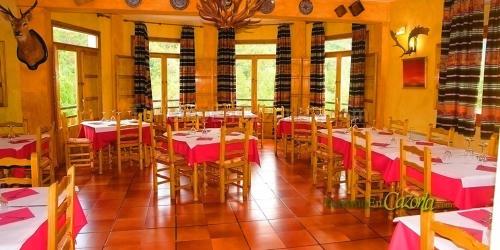 阿罗约弗里奥MONTE PIEDRA的用餐室配有红色和白色桌布的桌子