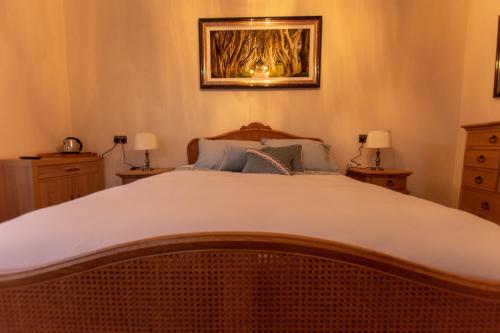 邓吉文The Gatelodge的一间卧室配有一张带两盏灯的大型白色床。
