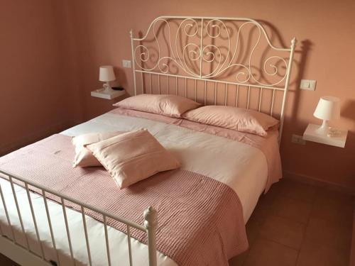 诺切劳恩布拉Appartamenti Monte Alago的卧室配有一张大床,配有粉色床单和枕头