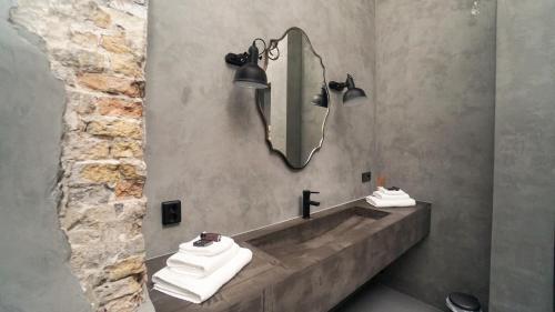 吕伐登Cosy Cityhouse Leeuwarden的浴室配有带镜子的盥洗盆和毛巾