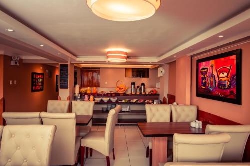 库斯科普林西比三世酒店的一间带桌椅的餐厅和一间厨房