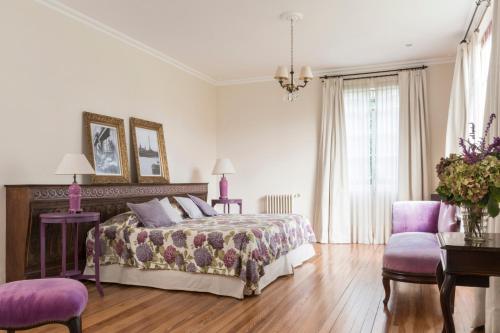 坦迪尔Casa Chacabuco Tandil的一间卧室配有一张床和两张紫色椅子