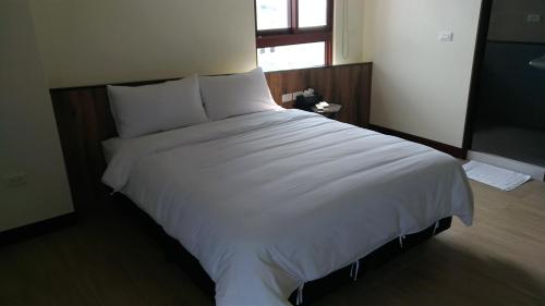 马公热带鱼民宿 的卧室内的一张大白色床,带有窗户