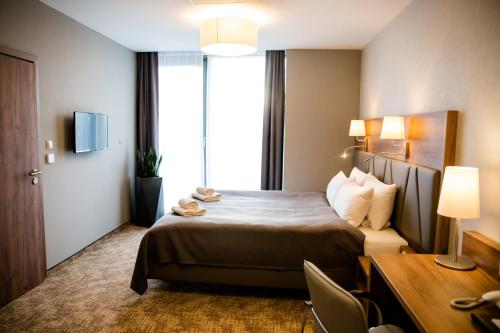 热舒夫APART HOTEL 12的配有一张床和一张书桌的酒店客房