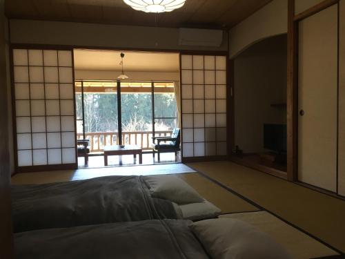 由布市山荘 紗羅樹 Syaranoki的客房设有一张床,享有庭院的景色