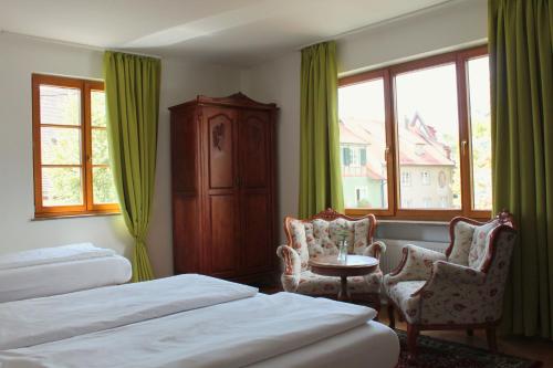 梅尔斯堡维多莉亚酒店的酒店客房带两张床和一张桌子以及椅子。