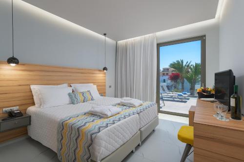 依克希亚阿夫拉海滩度假酒店的一间卧室配有一张床、一张书桌和一台电视